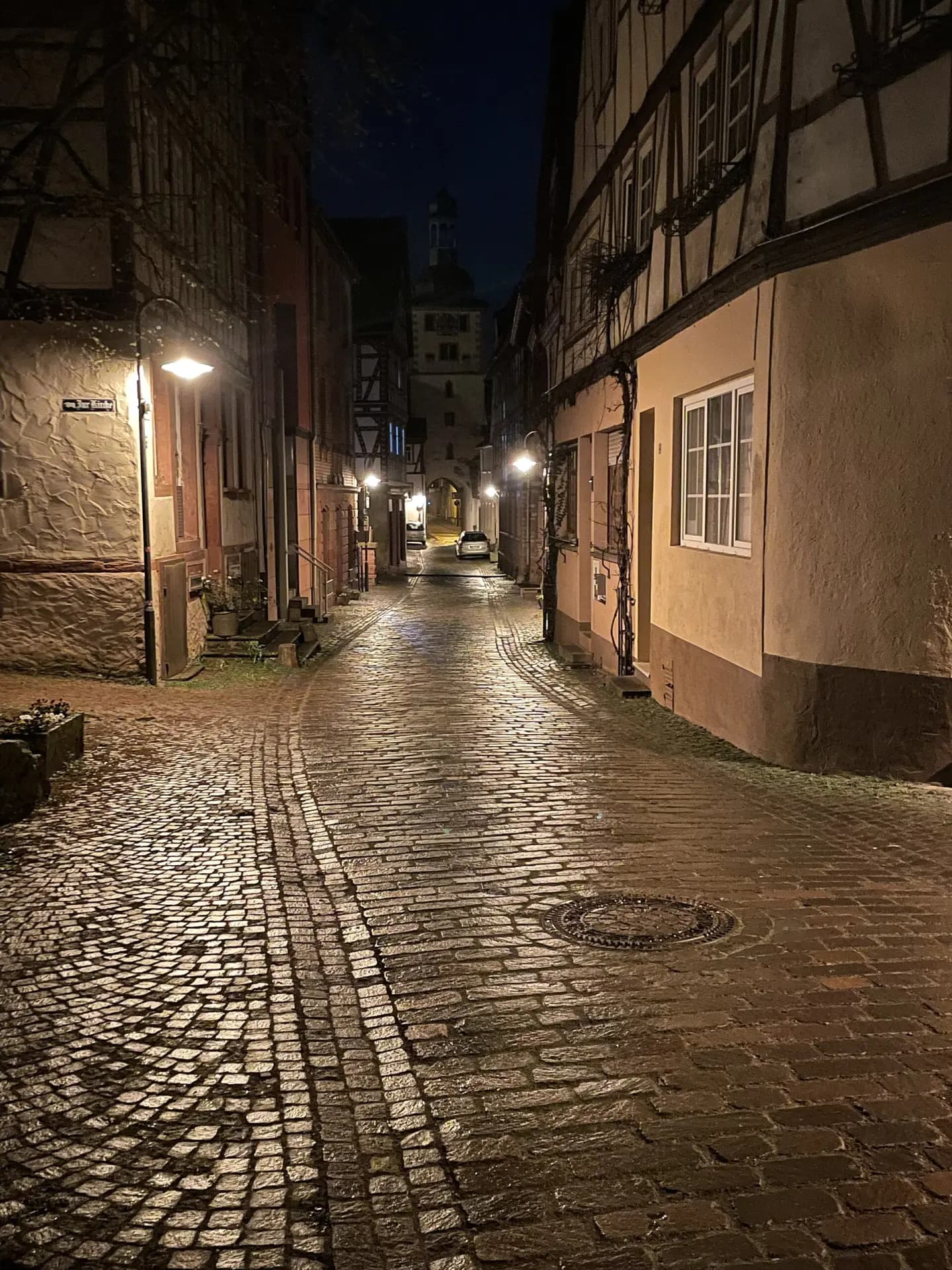 Beleuchtete Altstadtgasse mit Kopfsteinpflaster in Klingenberg am Main