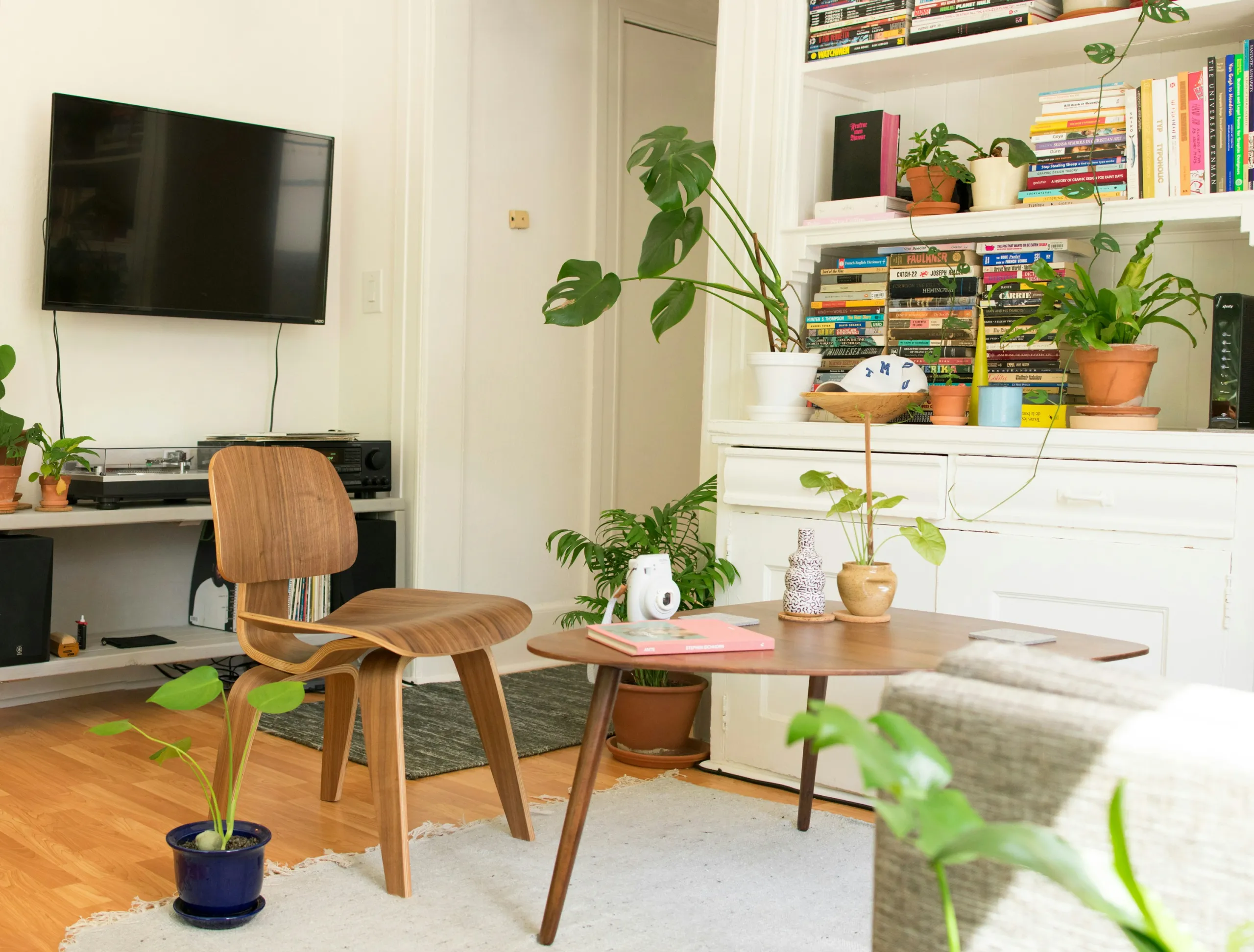 Wohnzimmer mit Holzstuhl, rundem Couchtisch und Bücherwand