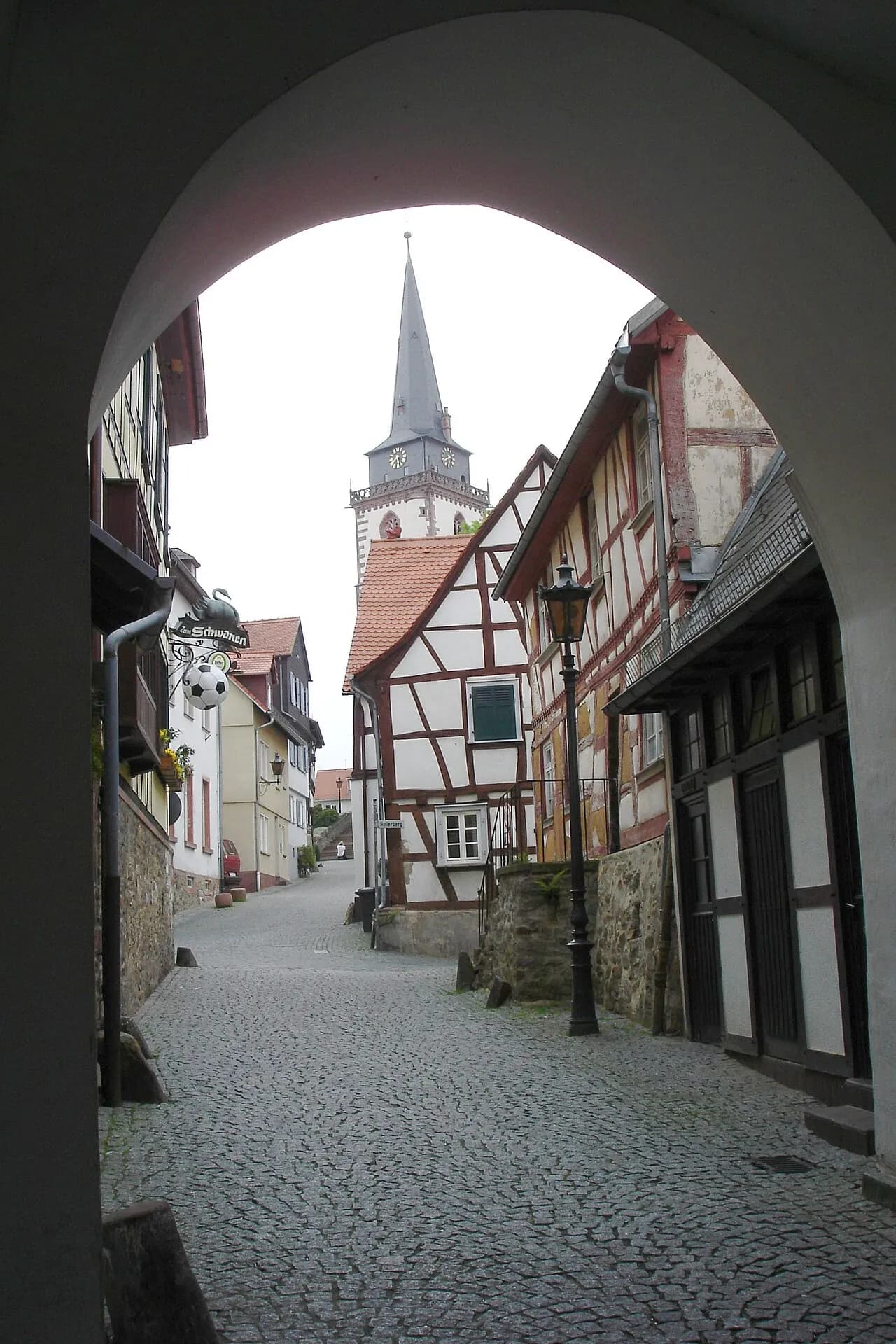 Blick durch einen Torbogen zur St.-Ursula-Kirche in Oberursel (Taunus)