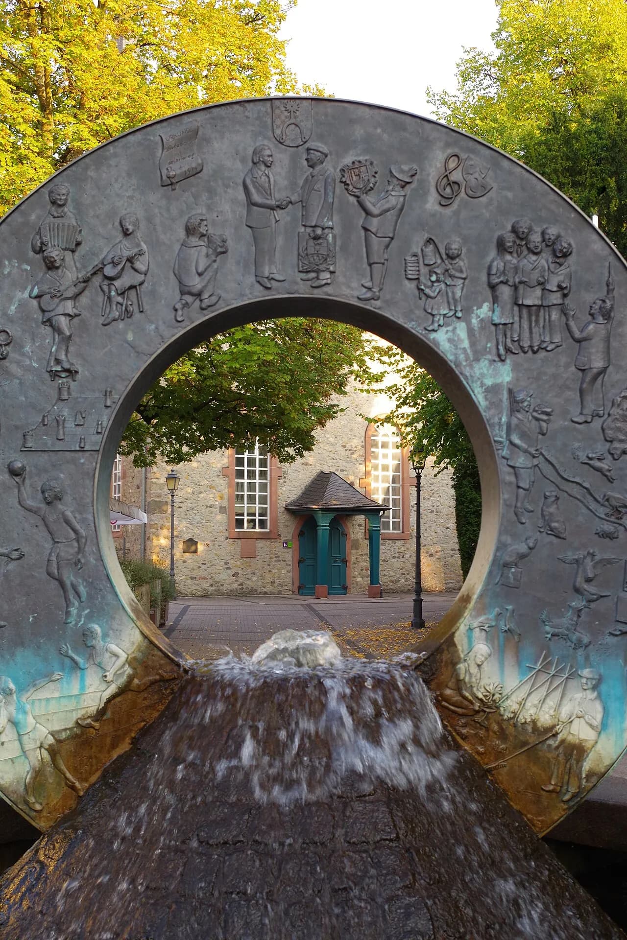 Bürgerbrunnen mit Blick auf die evangelische Kirche in Sulzbach (Taunus)