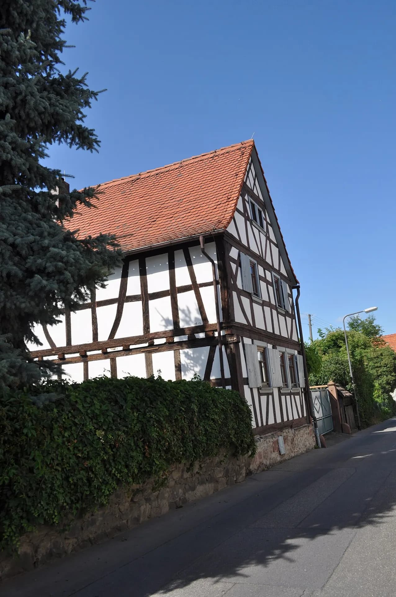 Fachwerkhaus mit rotem Ziegeldach am Eschbachsteg in Frankfurt Nieder-Eschbach
