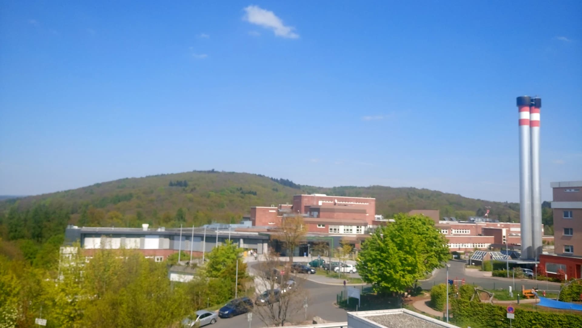 Blick über das Klinikum zum bewaldeten Gartenberg bei Hösbach
