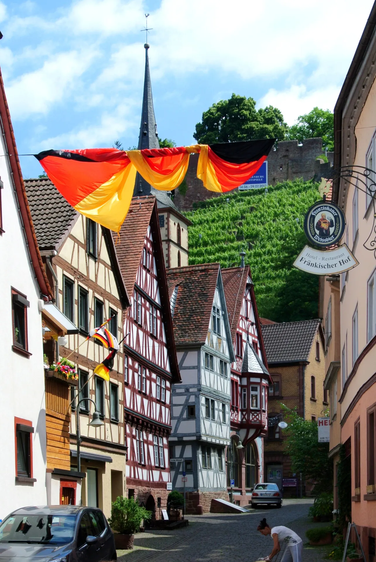 Mit Fahnen geschmückte Altstadtgasse unterhalb der Weinberge in Klingenberg am Main