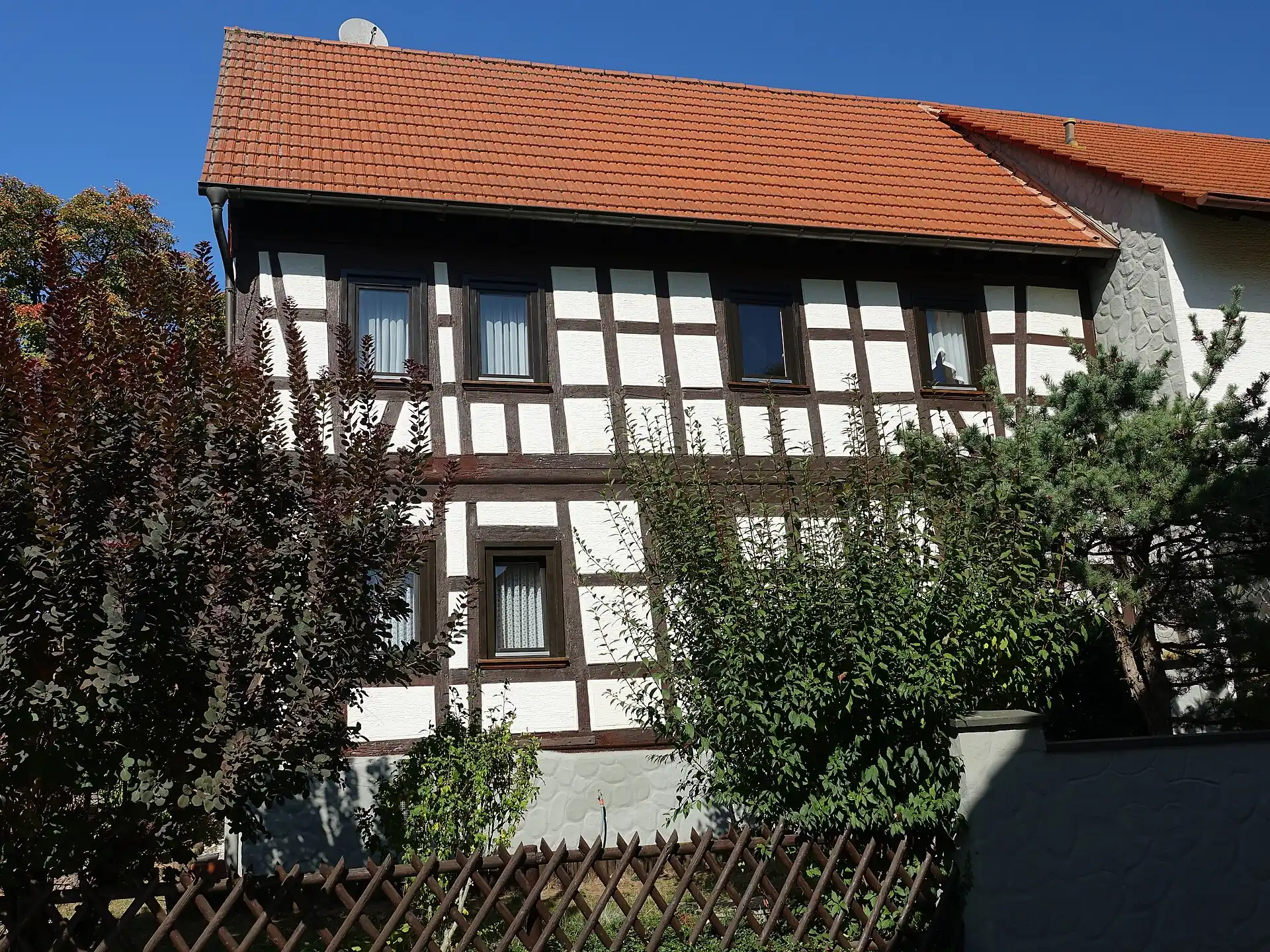 Fachwerkhaus hinter Gartenhecke in der Straße Hinter der Kirche in Hanau-Mittelbuchen
