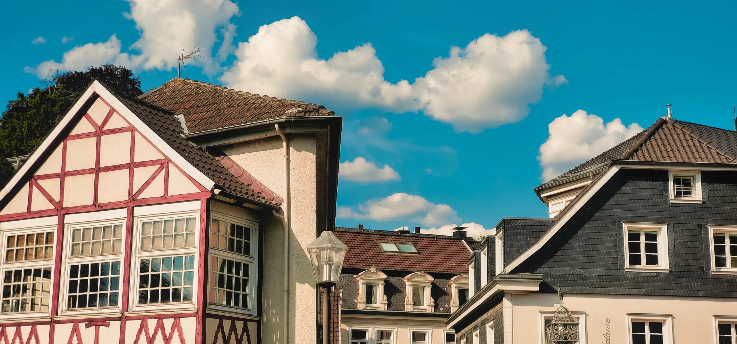 Fachwerkgiebel und Schieferhaus unter blauem Himmel
