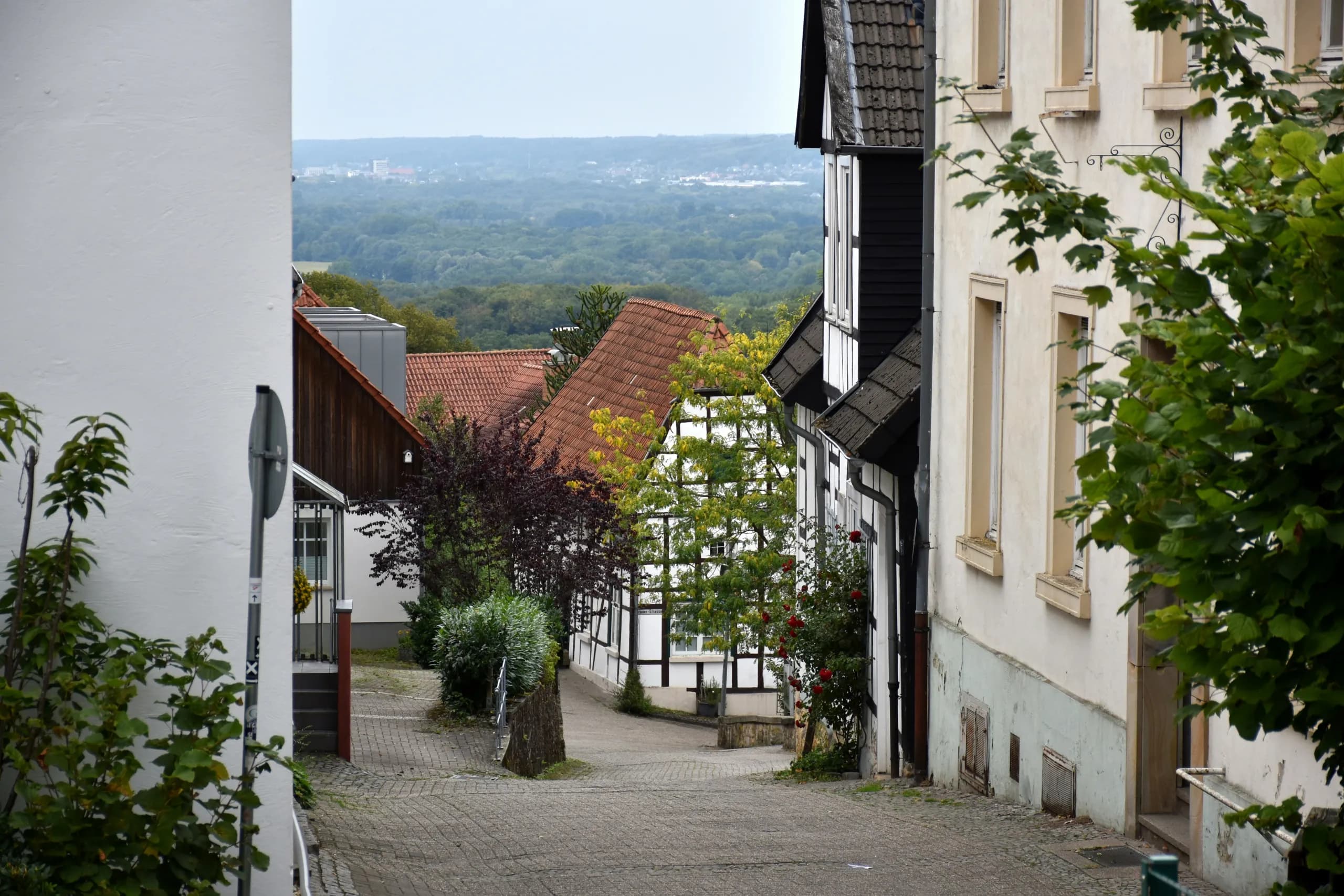 Gasse mit Fachwerkhäusern und Blick über das Umland