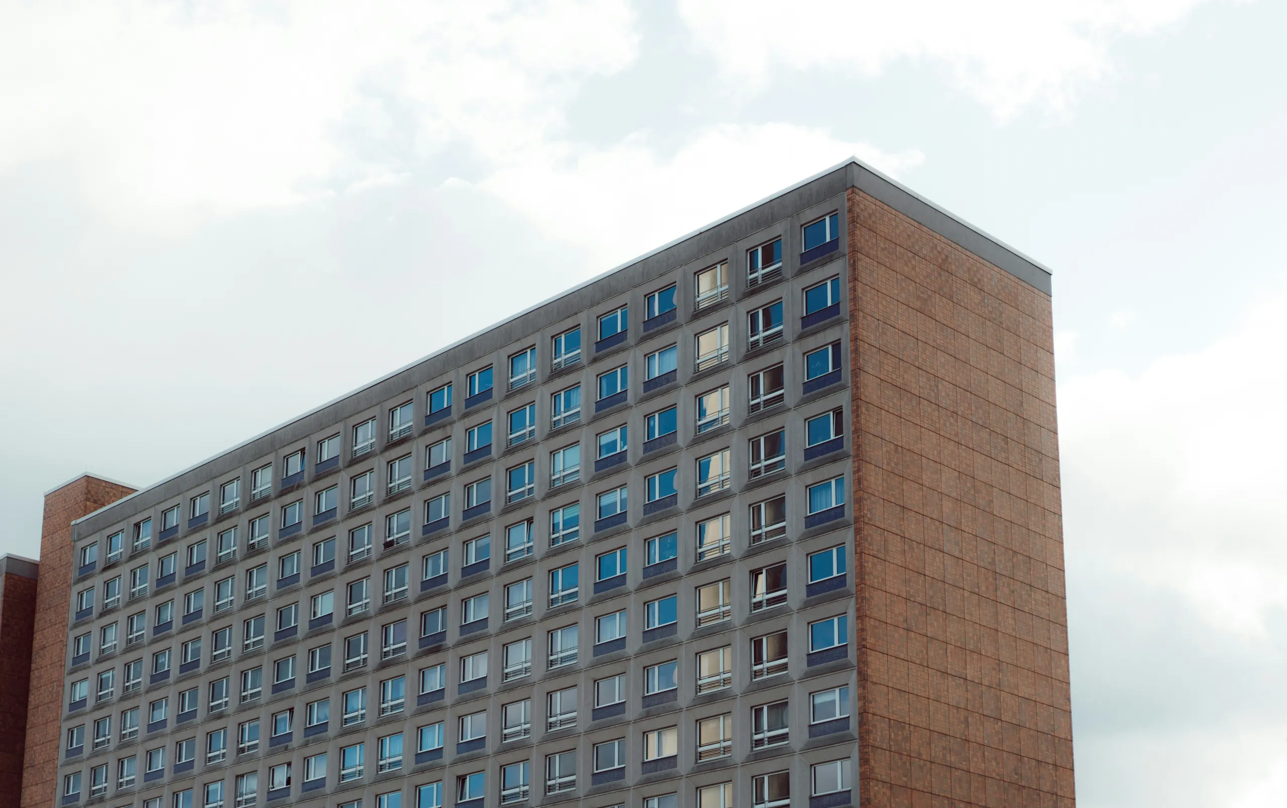 Wohnhochhaus mit Rasterfassade und Backsteinflanke