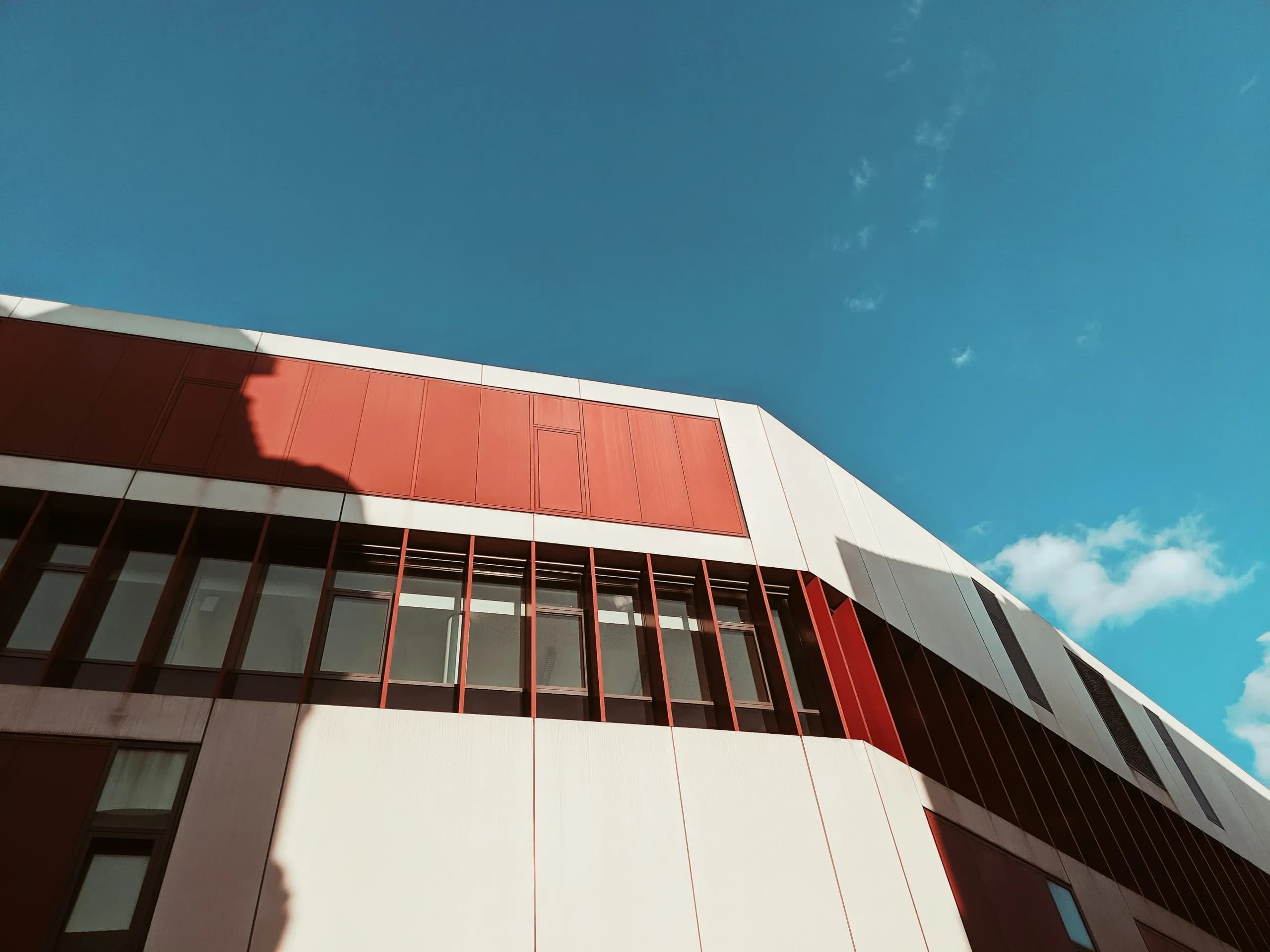 Moderner Wohn- und Geschäftsbau mit rot-weißer Fassade