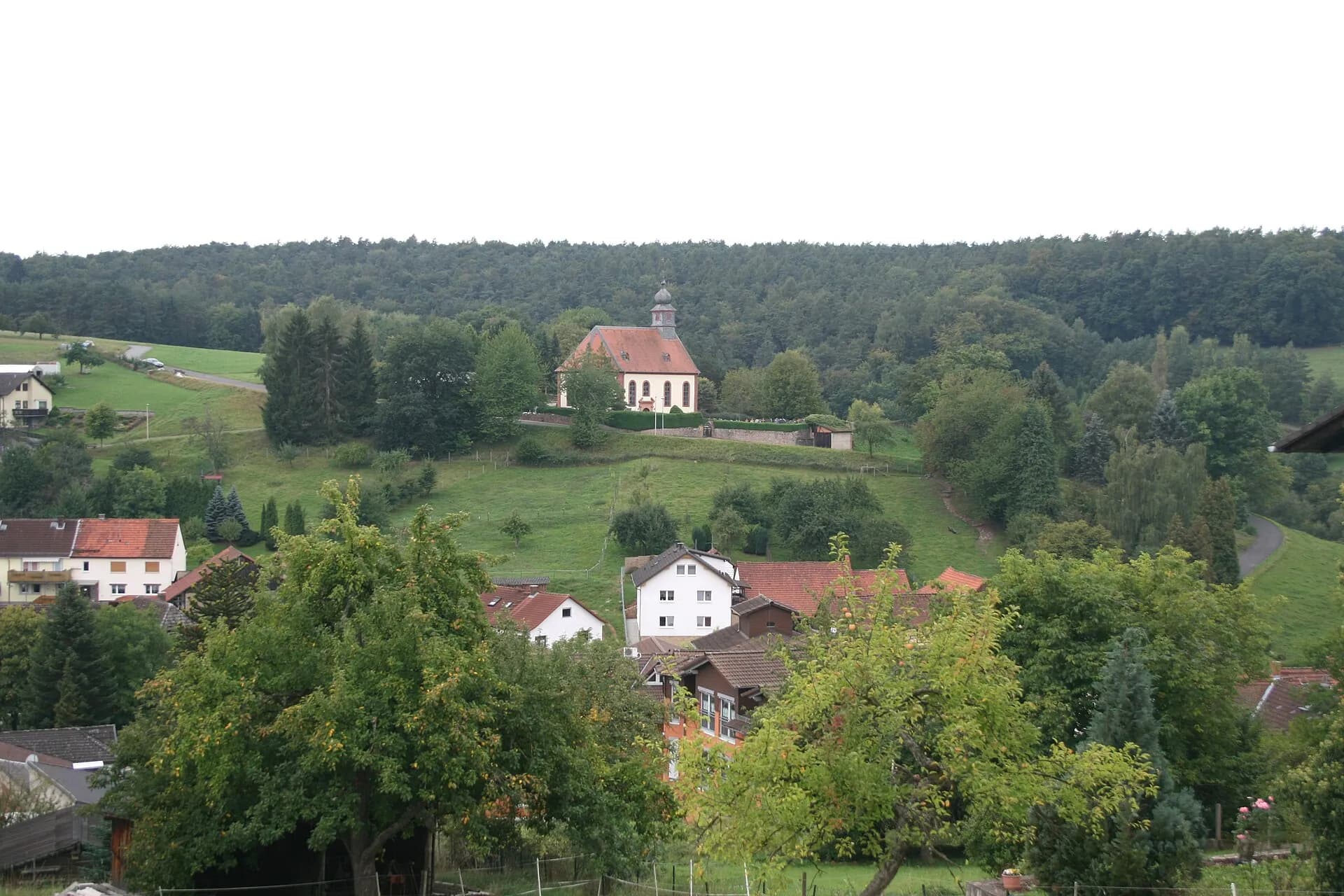 Ortsansicht mit Kirche über dem Odenwaldtal in Lützelbach