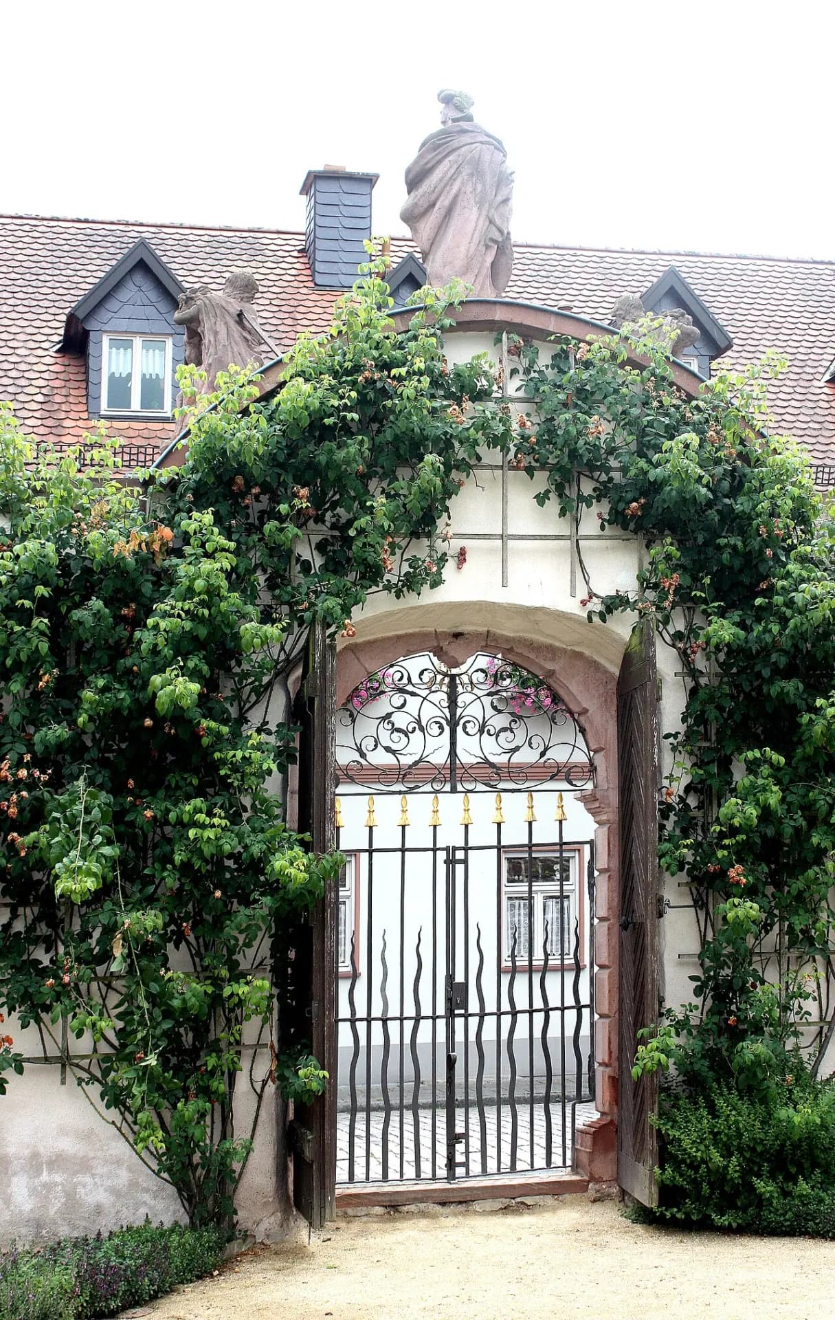 Schmiedeeisernes Klostergartentor mit Rosen in Seligenstadt