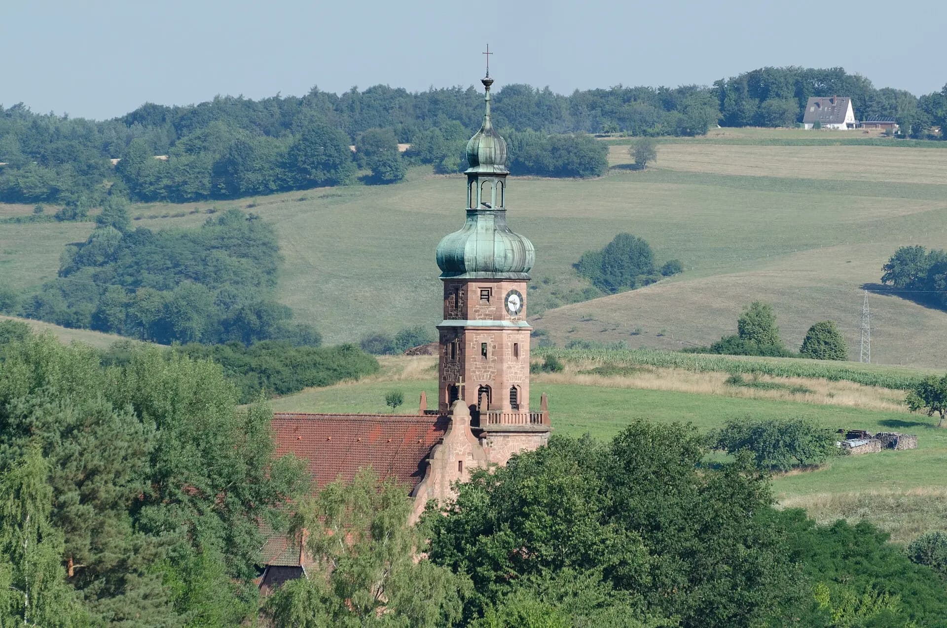 Kirchturm von Oberbessenbach über der Spessartlandschaft in Bessenbach