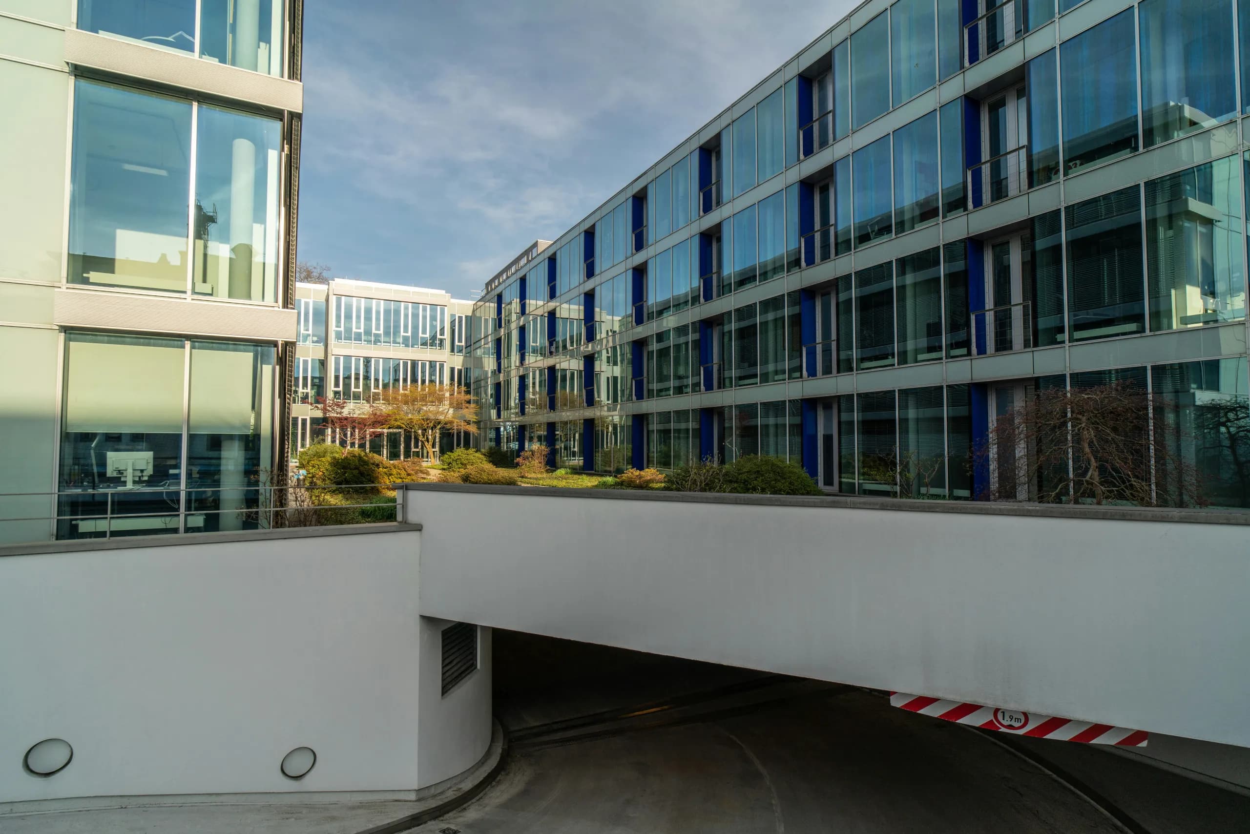 Verglaster Bürocampus mit begrüntem Innenhof und Tiefgarage