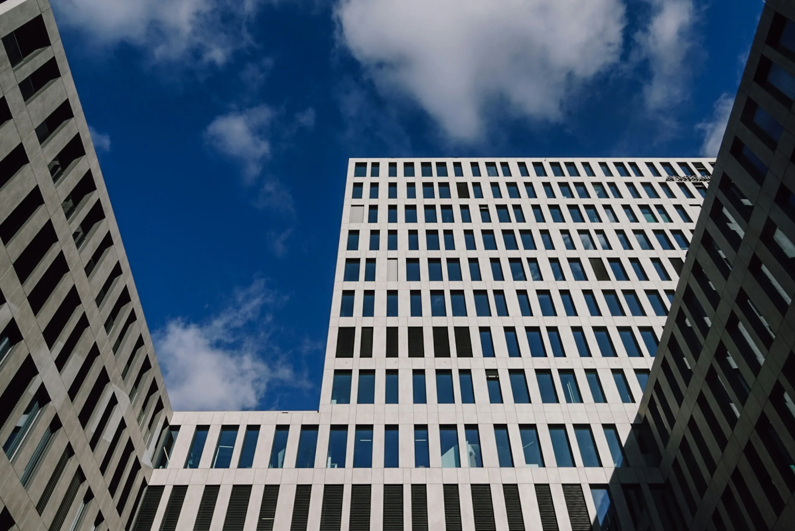Innenhof eines Bürokomplexes mit heller Rasterfassade