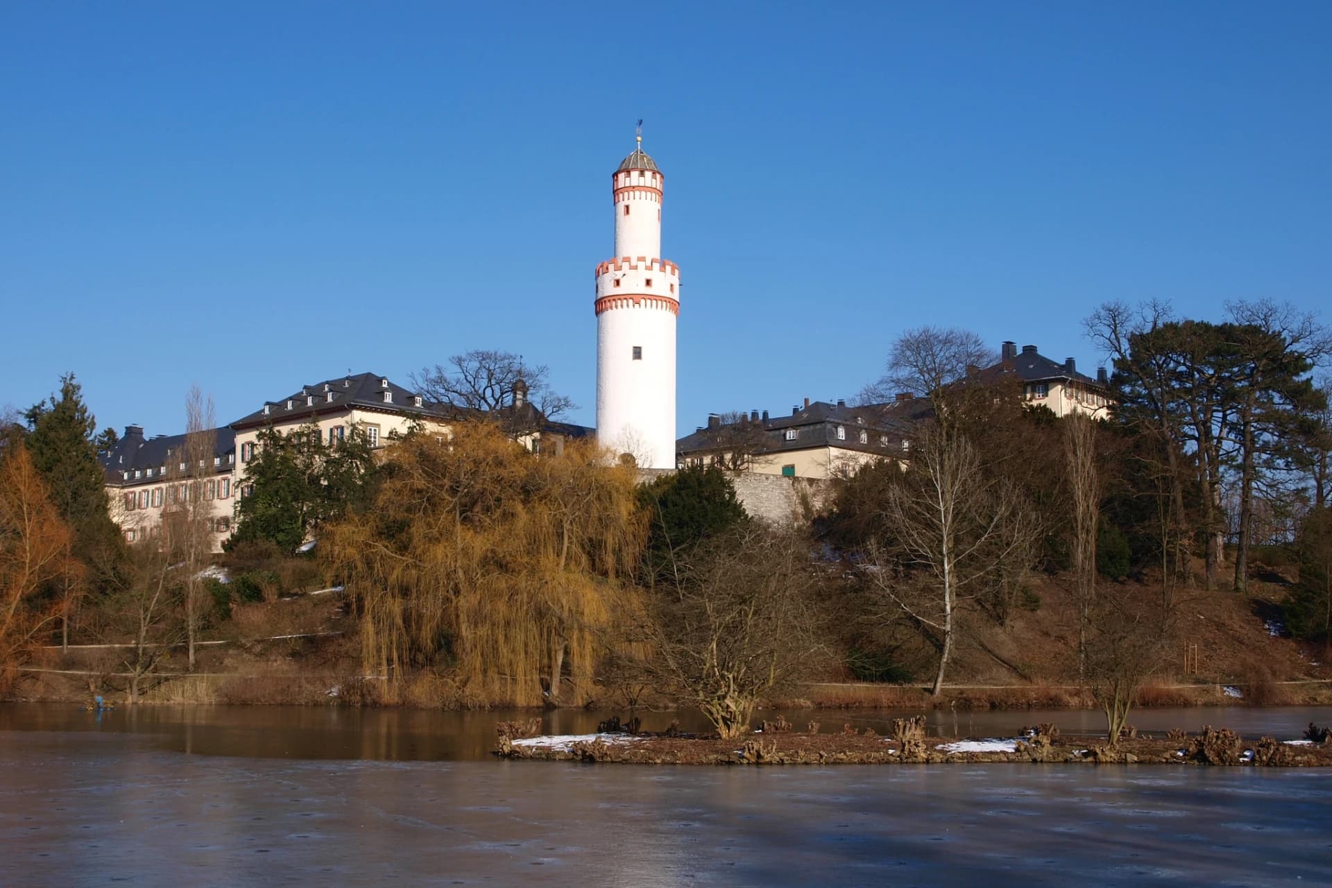 Weißer Turm und Schloss über dem zugefrorenen Schlossweiher in Bad Homburg