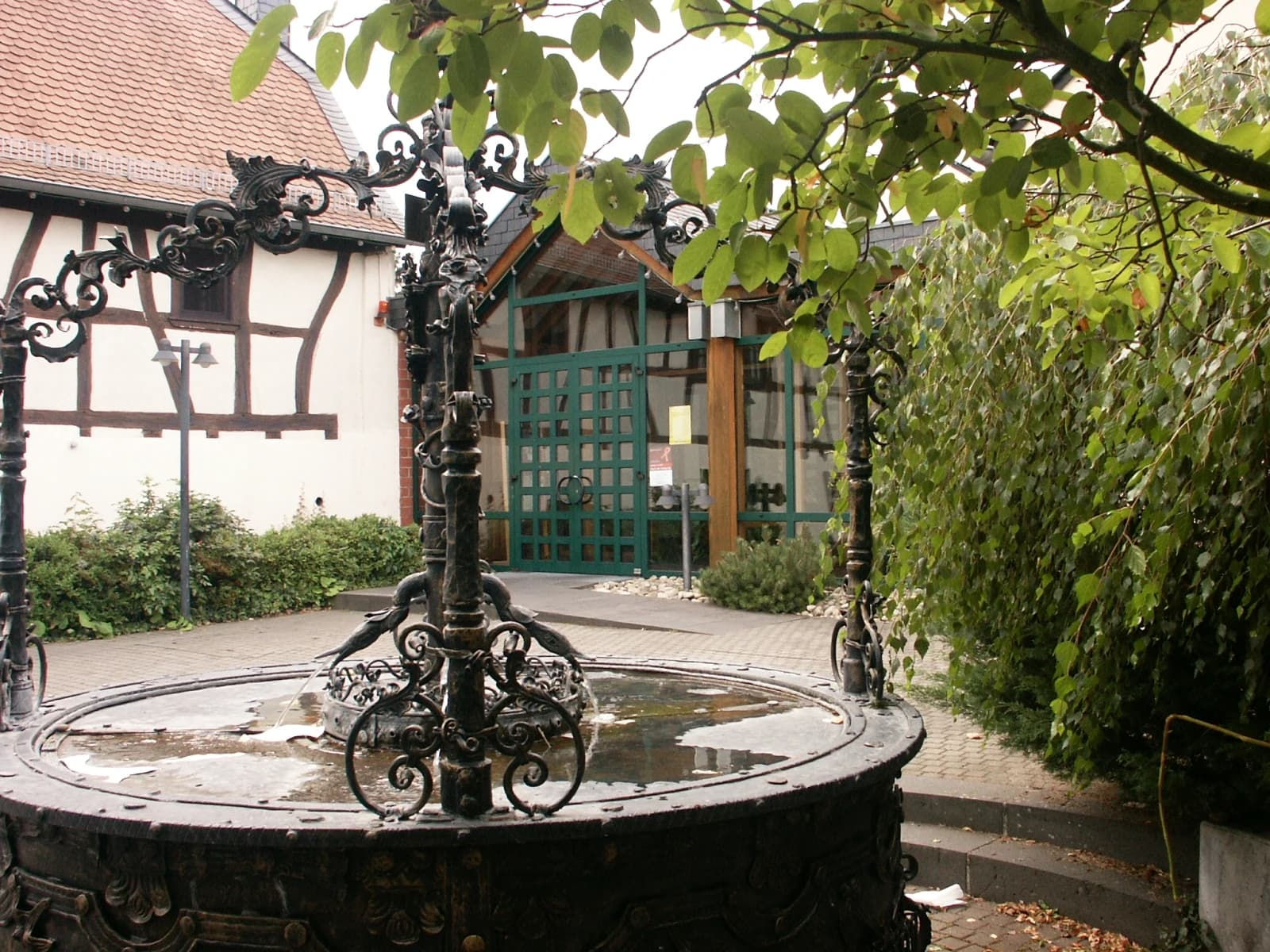 Schmiedeeiserner Brunnen vor Fachwerkhäusern in Rodgau