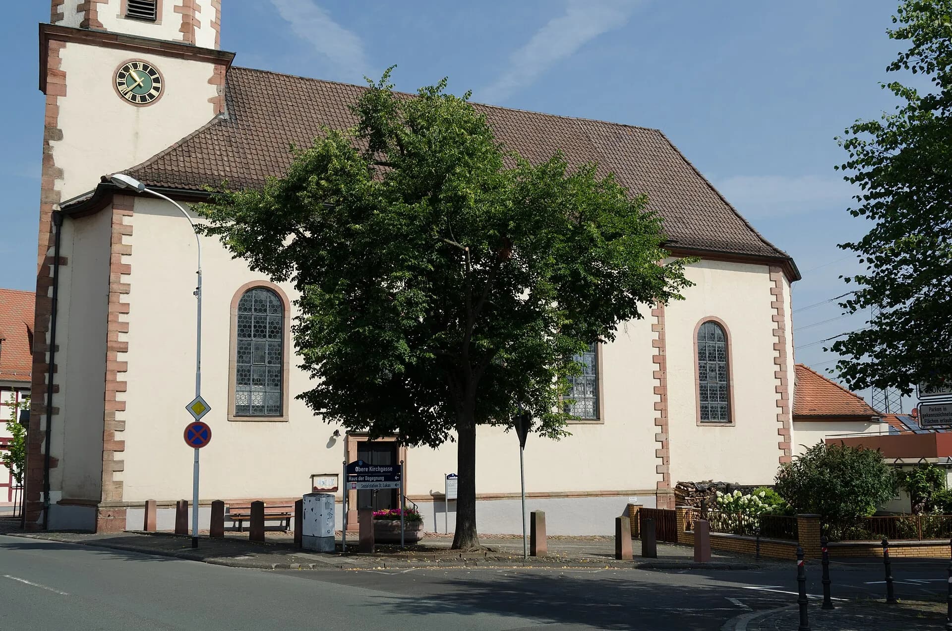 Pfarrkirche St. Leonhard mit Baum am Kirchplatz in Stockstadt am Main