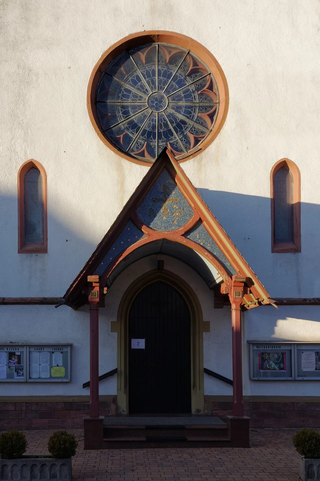 Eingangsportal mit Fensterrose der Kirche St. Rochus in Rodgau-Hainhausen