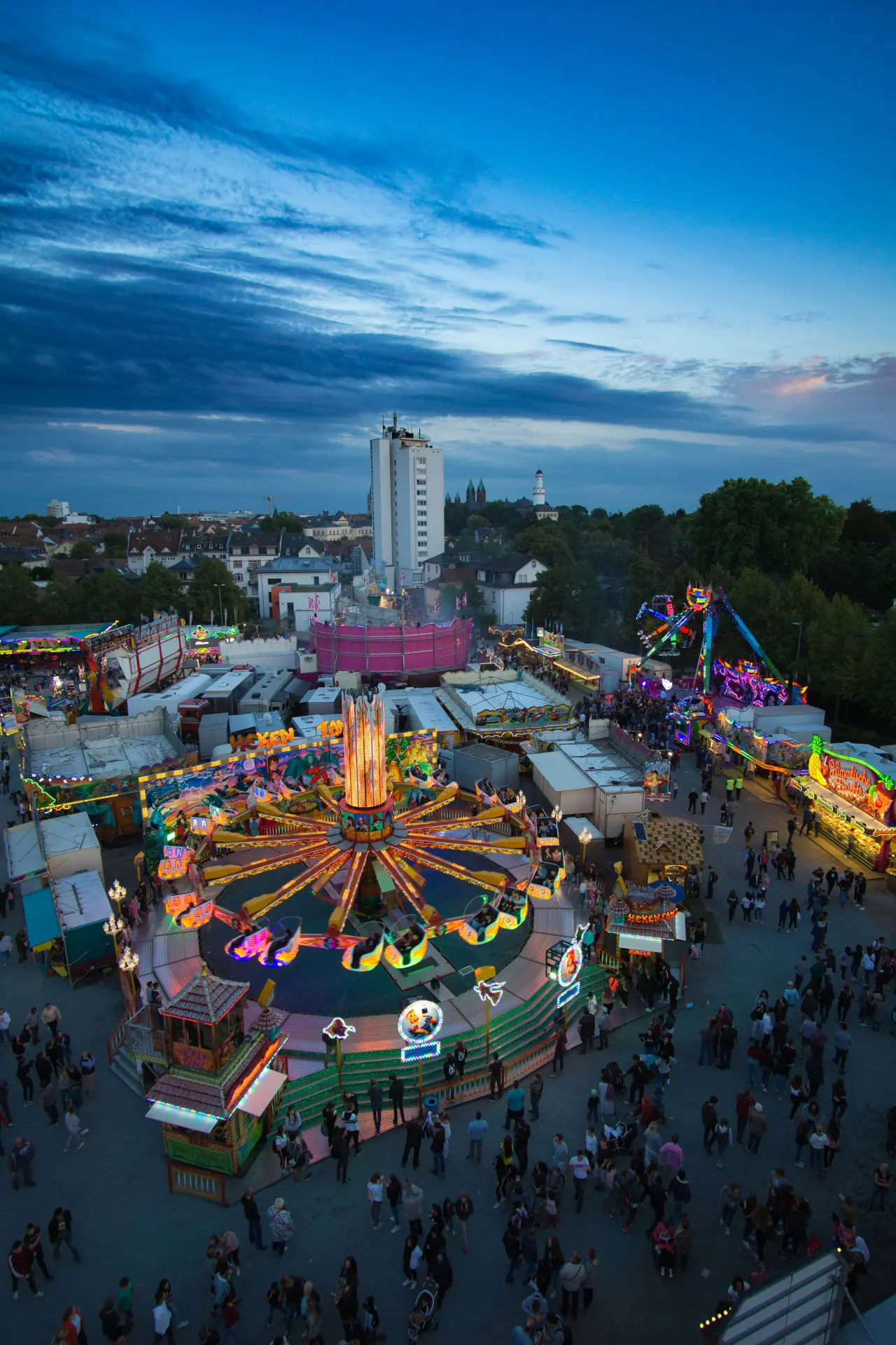 Luftaufnahme eines Volksfests mit Fahrgeschäften und Ständen in der Abenddämmerung in Bad Homburg